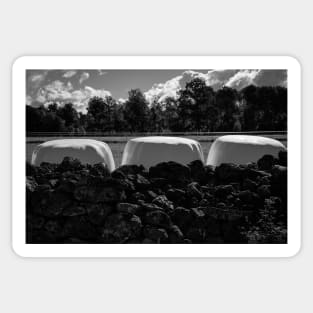 Dramatic clouds in the sky over the dark Swedish forest and the  white rolls with straw, Sticker